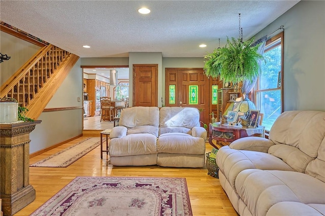 living room with light wood-type flooring and a textured ceiling