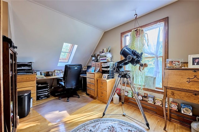 home office with a healthy amount of sunlight, lofted ceiling, and light hardwood / wood-style floors