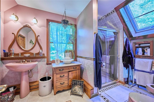 bathroom with vaulted ceiling with skylight, tile patterned flooring, a healthy amount of sunlight, and walk in shower