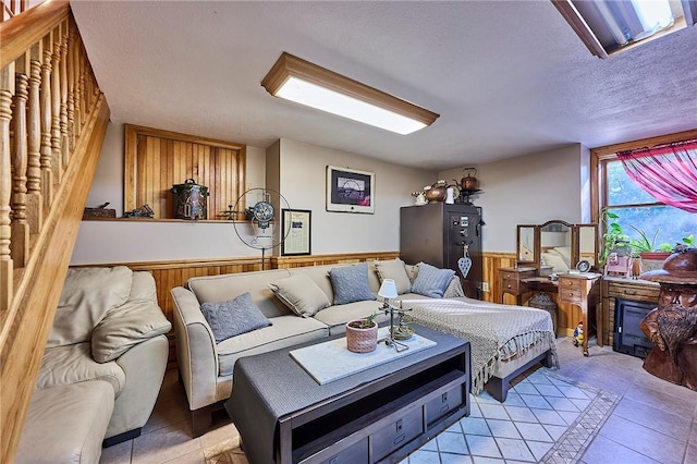 tiled living room with a textured ceiling and wood walls