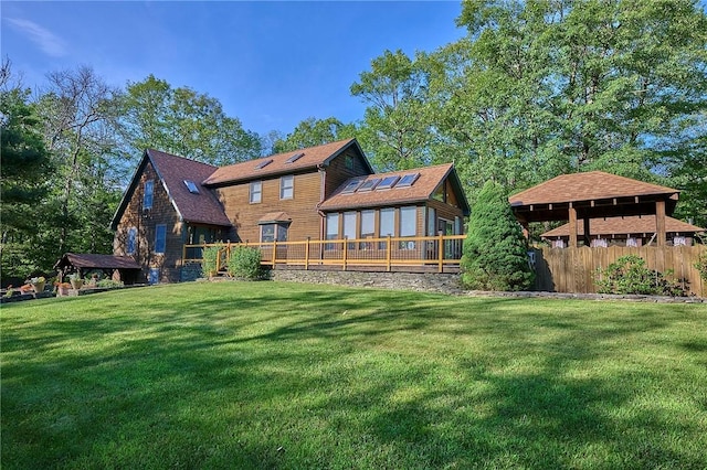 back of house featuring a wooden deck and a yard