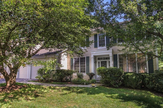 view of front facade with a garage, a front yard, and driveway