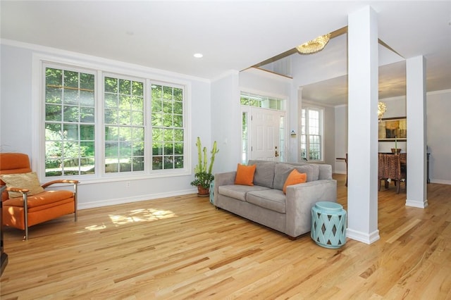 sitting room featuring light wood-type flooring, baseboards, and ornamental molding