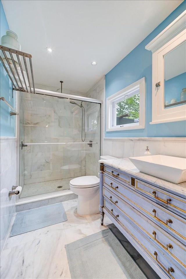 bathroom featuring vanity, a shower with shower door, and toilet