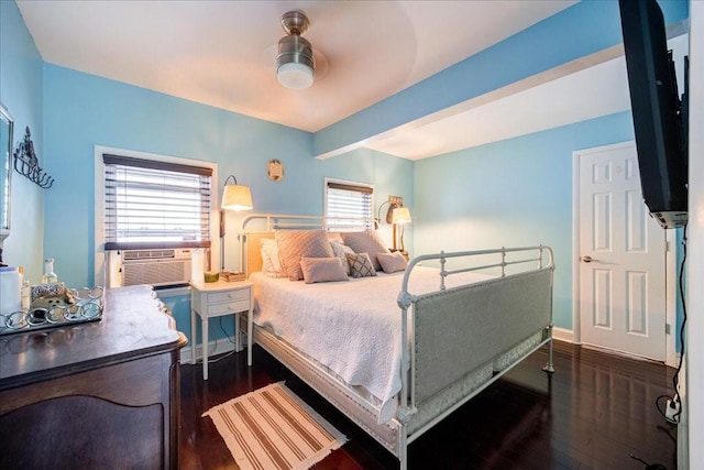 bedroom featuring ceiling fan, cooling unit, and dark wood-type flooring