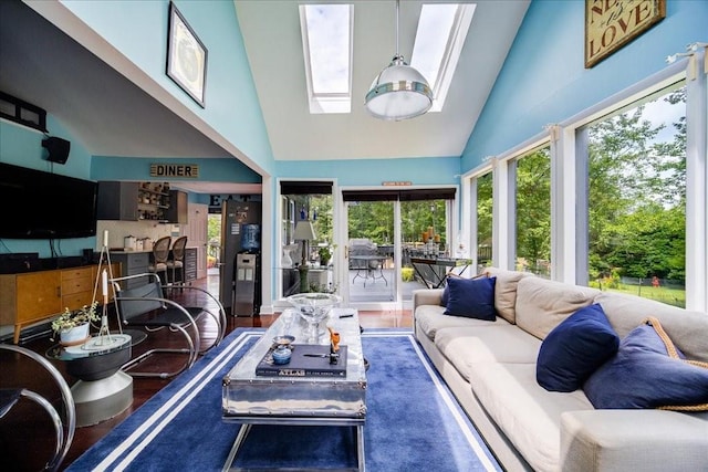 living room with dark hardwood / wood-style flooring, a skylight, and high vaulted ceiling