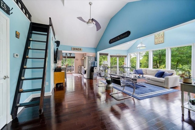 living room with plenty of natural light, dark hardwood / wood-style flooring, and high vaulted ceiling