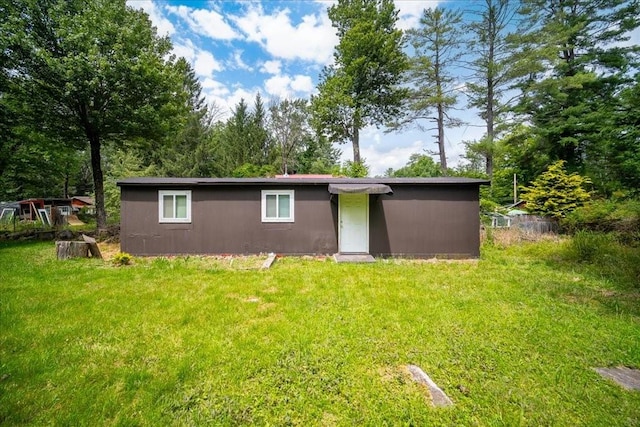 rear view of property featuring a lawn