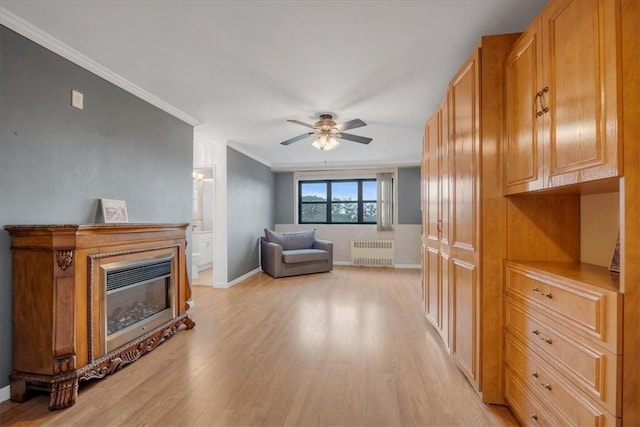 living room with radiator heating unit, light hardwood / wood-style flooring, ceiling fan, and crown molding