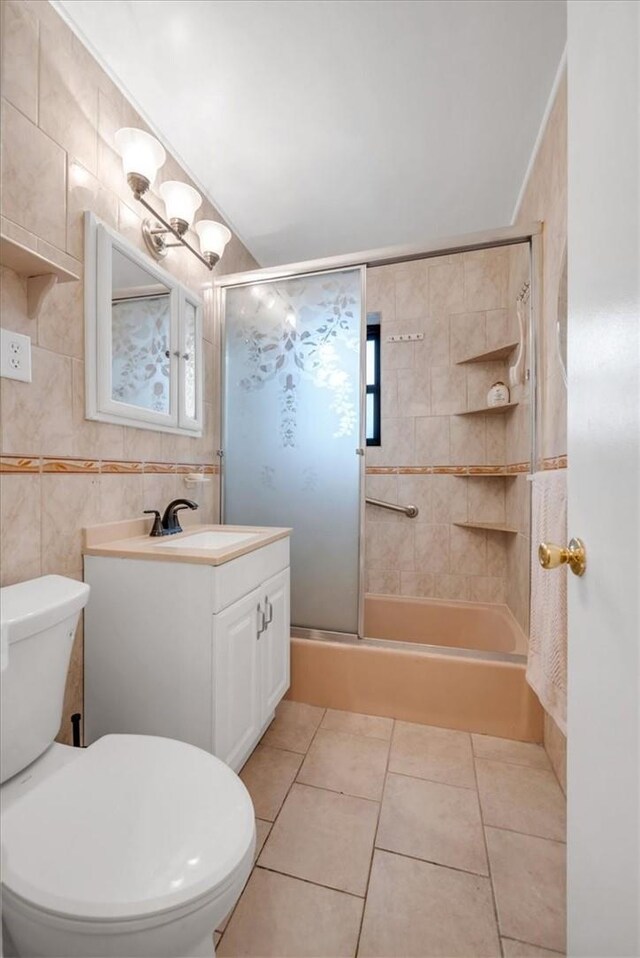 bathroom with tile patterned flooring, vanity, toilet, and tile walls