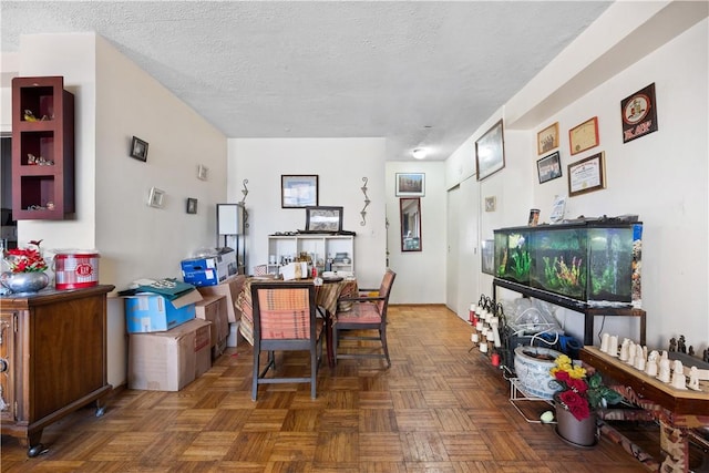 dining area with dark parquet flooring and a textured ceiling