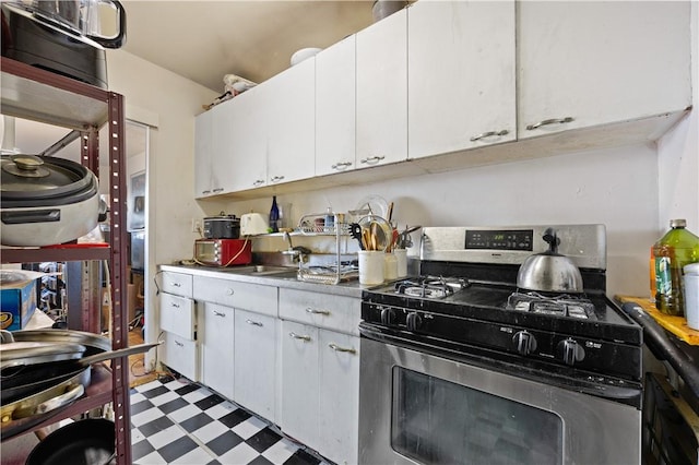 kitchen with white cabinetry, stainless steel range with gas cooktop, and sink