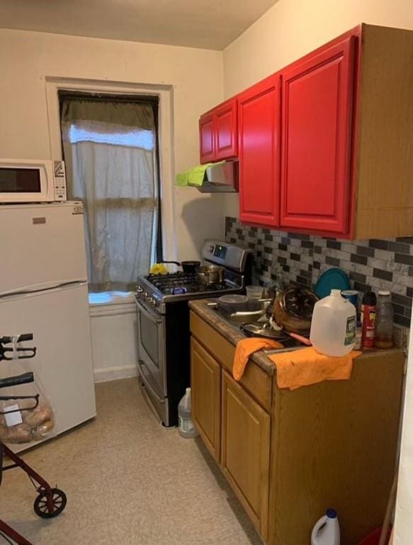 kitchen featuring white appliances, tasteful backsplash, and exhaust hood