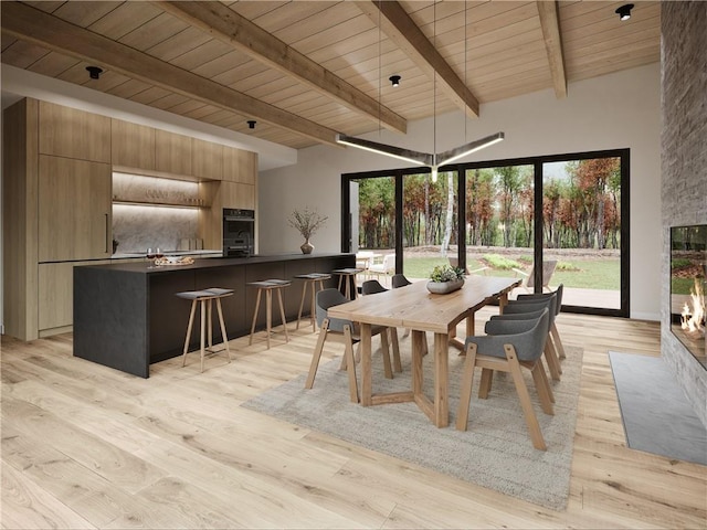 dining space with beamed ceiling, a high ceiling, light hardwood / wood-style flooring, and wood ceiling