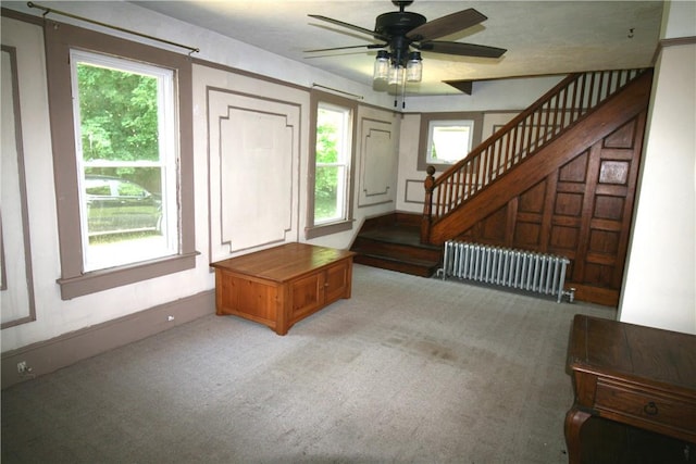 carpeted entryway with radiator heating unit, plenty of natural light, and ceiling fan