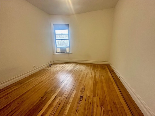 spare room featuring cooling unit and light hardwood / wood-style flooring