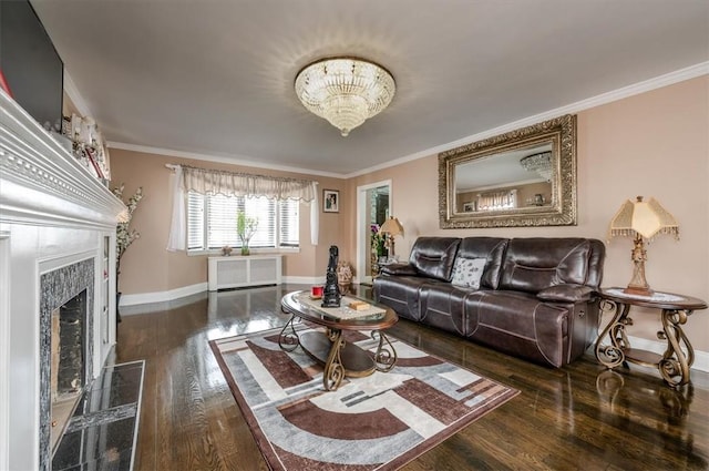 living room with radiator heating unit, ornamental molding, dark wood-type flooring, and an inviting chandelier