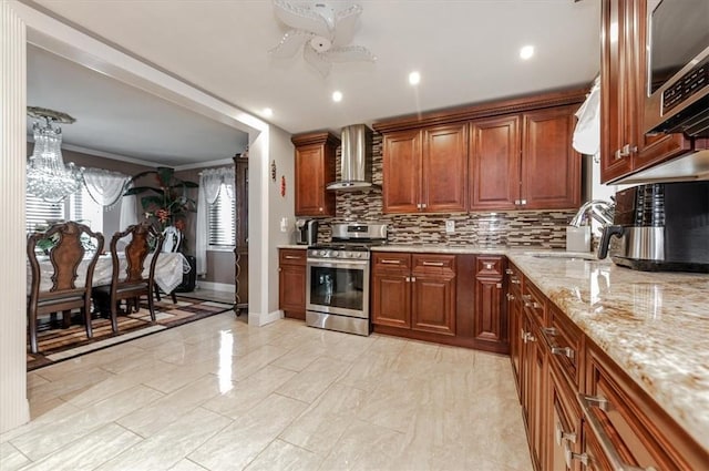 kitchen with sink, stainless steel appliances, a healthy amount of sunlight, and wall chimney range hood