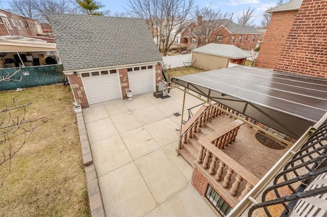 view of patio with an outbuilding and a garage