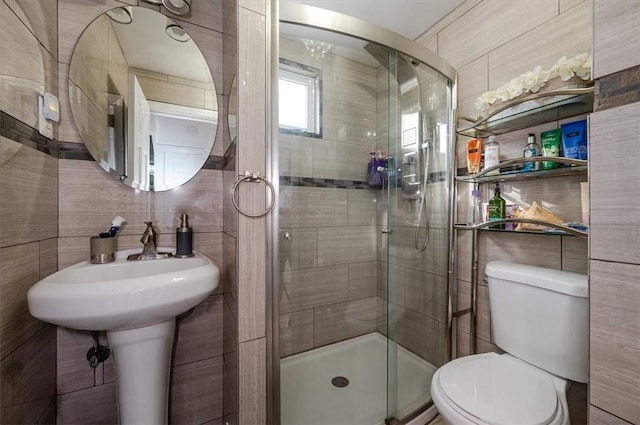 bathroom with toilet, an enclosed shower, and tile walls