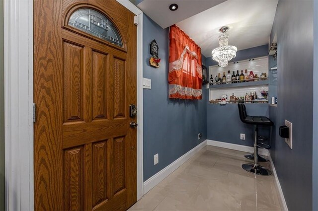 entrance foyer featuring a chandelier and light tile patterned floors