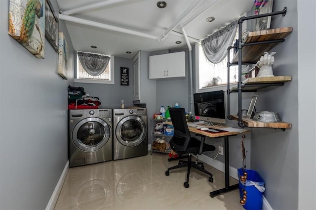 laundry room featuring washer and dryer, cabinets, and a healthy amount of sunlight