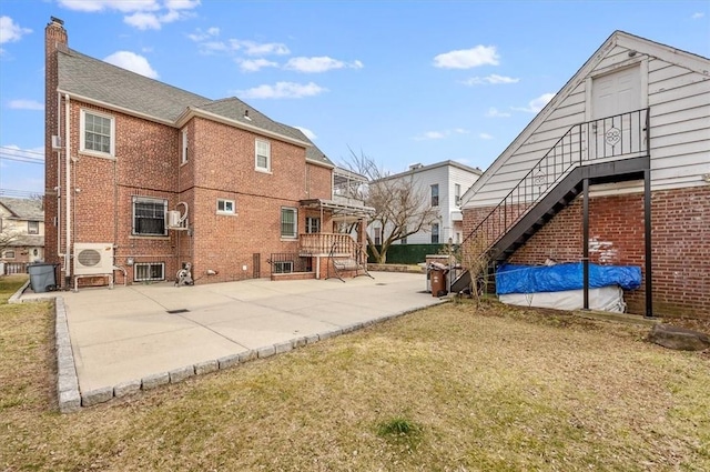 rear view of property featuring a yard and a patio