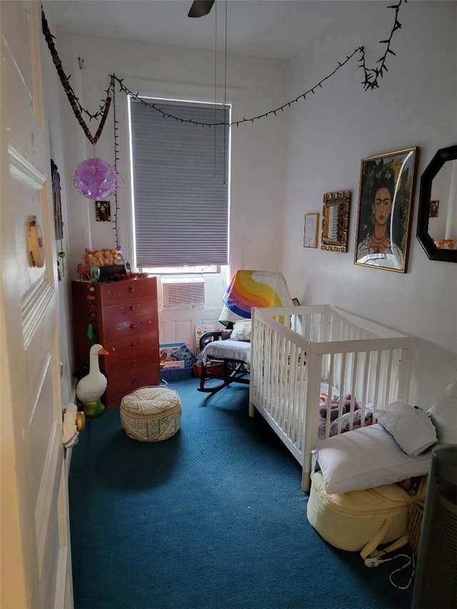 carpeted bedroom featuring ceiling fan, cooling unit, and a nursery area