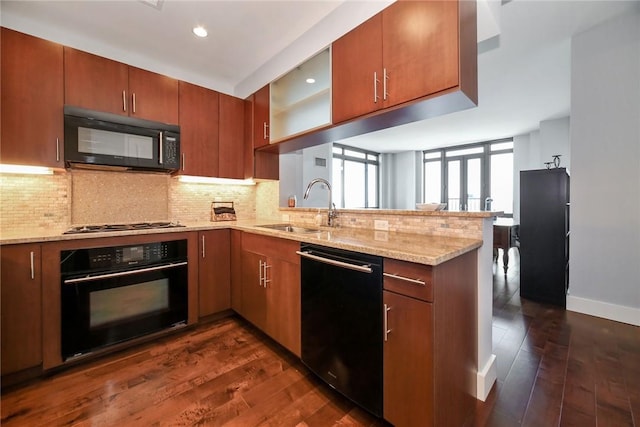 kitchen featuring black appliances, dark hardwood / wood-style flooring, kitchen peninsula, and sink