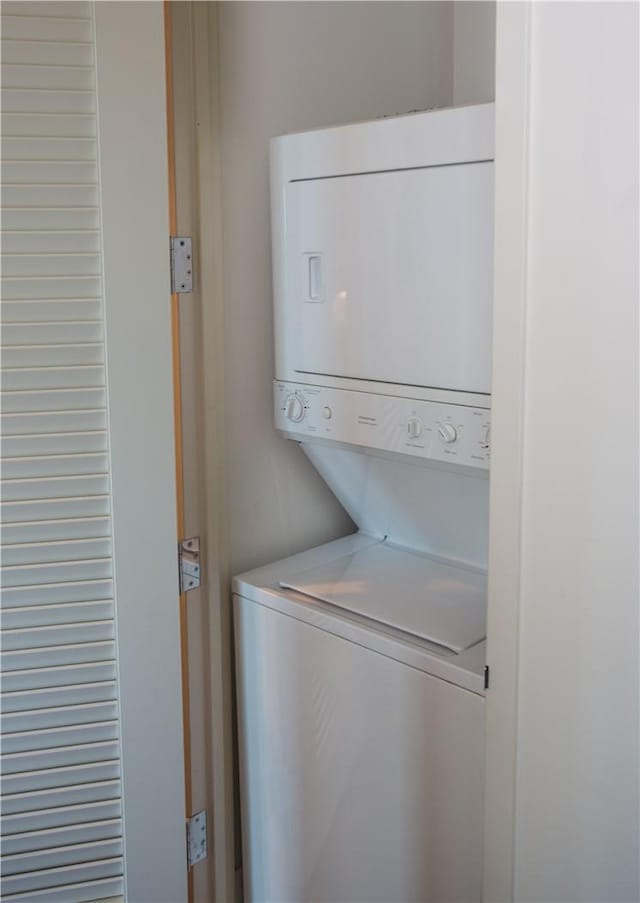 washroom featuring stacked washer and clothes dryer