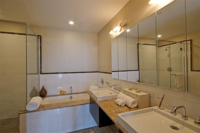 bathroom featuring separate shower and tub, sink, tile walls, and tile patterned flooring