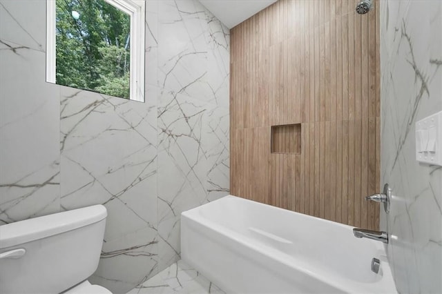 bathroom featuring tub / shower combination, toilet, and tile walls