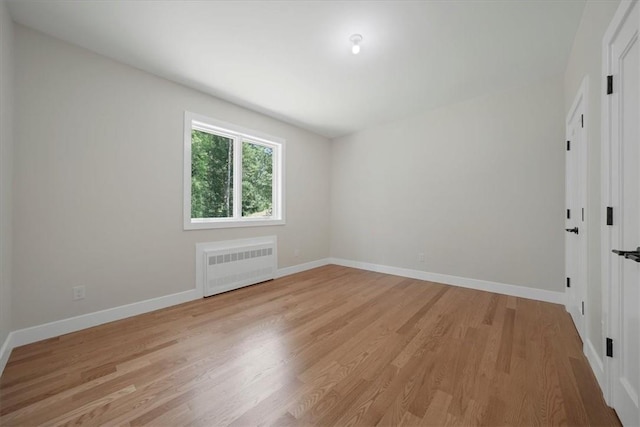 unfurnished room with light wood-type flooring and radiator heating unit