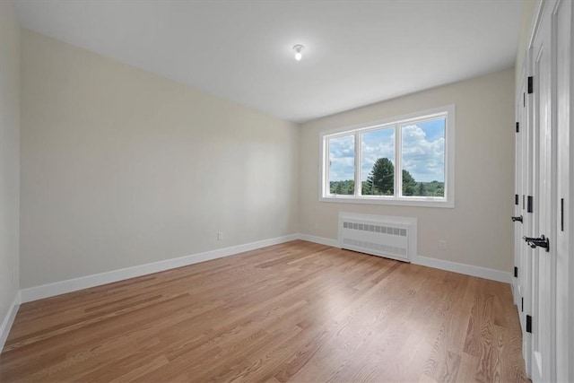 empty room featuring light hardwood / wood-style floors and radiator