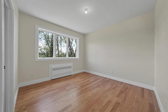 empty room featuring light wood-type flooring and radiator