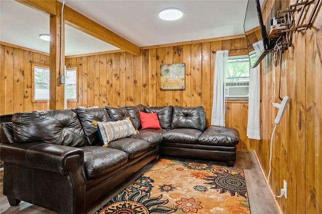 living room with beam ceiling, wooden walls, and hardwood / wood-style flooring