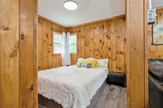 bedroom featuring hardwood / wood-style floors and wooden walls