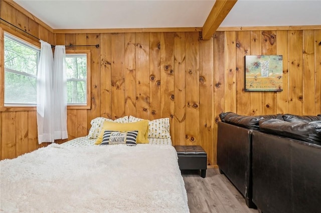 bedroom with hardwood / wood-style flooring, beam ceiling, and wood walls