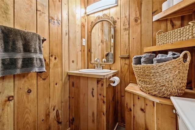 bathroom with vanity and wooden walls