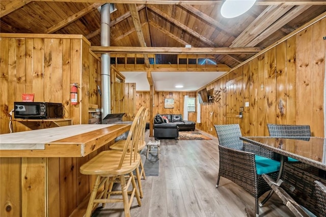 bar featuring vaulted ceiling with beams, wood walls, hardwood / wood-style floors, and wooden ceiling