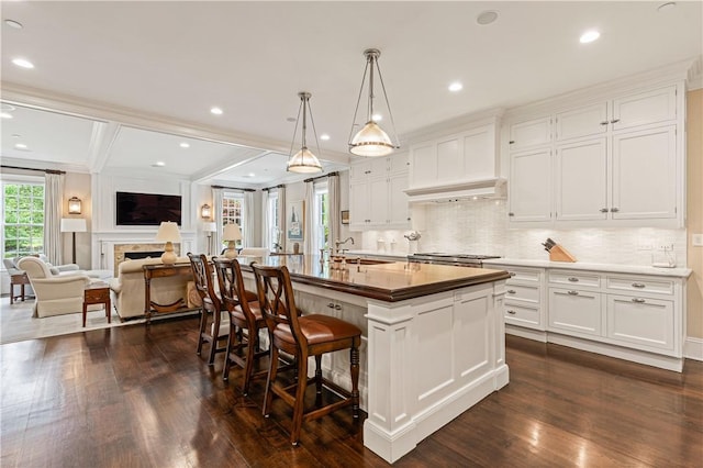 kitchen featuring white cabinetry, a kitchen island with sink, dark hardwood / wood-style flooring, and sink