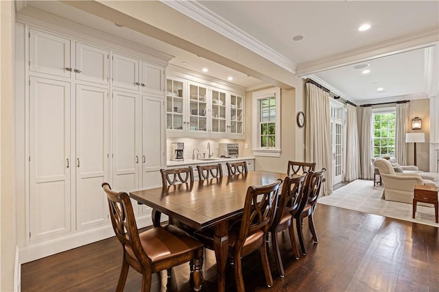 dining room featuring dark hardwood / wood-style flooring, plenty of natural light, and ornamental molding