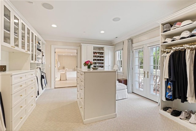 walk in closet featuring light carpet and french doors