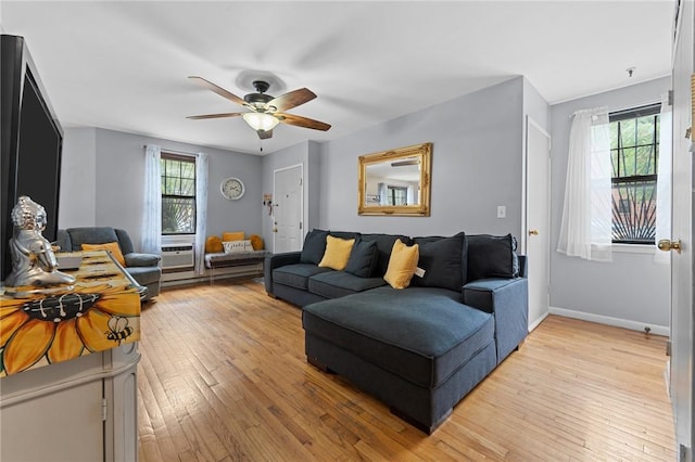 living room with plenty of natural light, ceiling fan, and light wood-type flooring