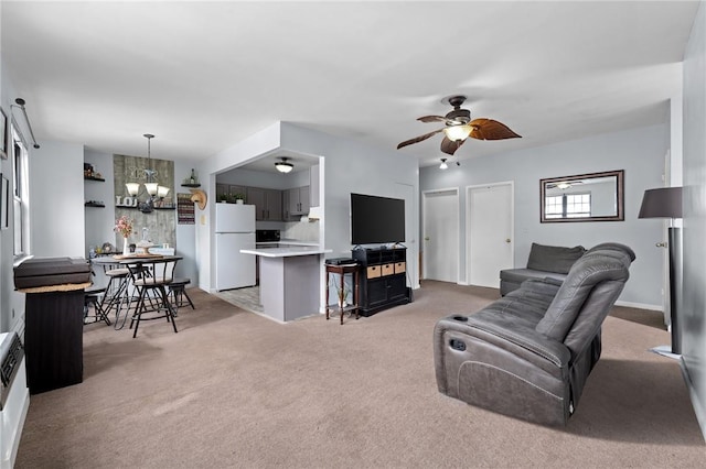 carpeted living room featuring ceiling fan with notable chandelier