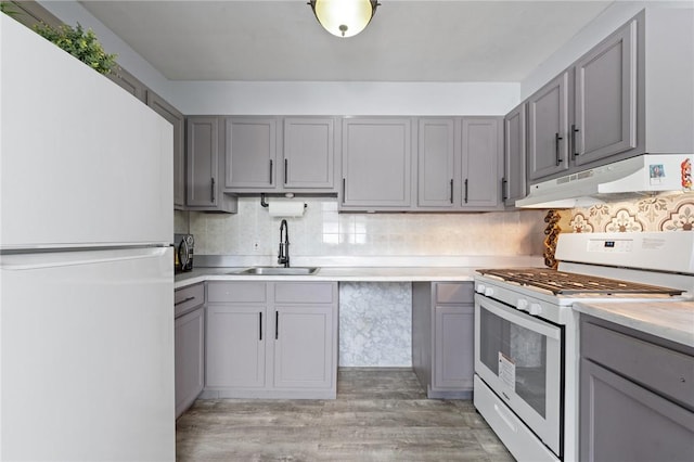 kitchen featuring gray cabinets, sink, light hardwood / wood-style floors, and white appliances