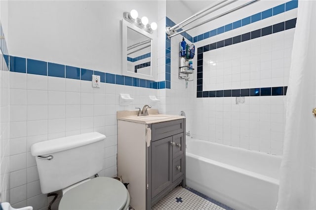 full bathroom featuring shower / bath combo, tile patterned floors, toilet, vanity, and tile walls