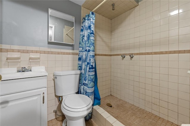 bathroom with toilet, vanity, tile walls, and walk in shower