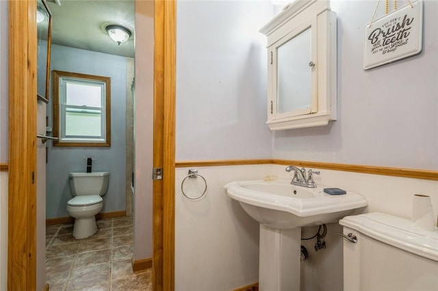 bathroom featuring baseboards and toilet