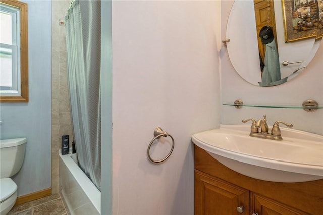 bathroom featuring tile patterned flooring, toilet, shower / tub combo, vanity, and baseboards